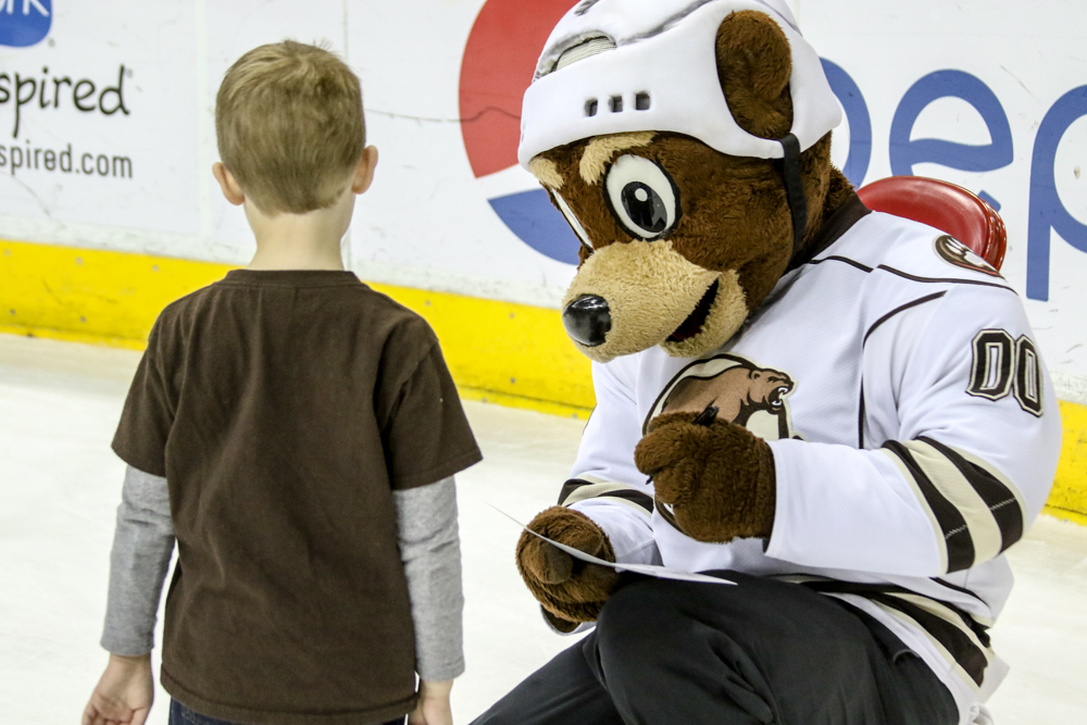 Coco The Bear Adds His Paw Print To A Team Photo